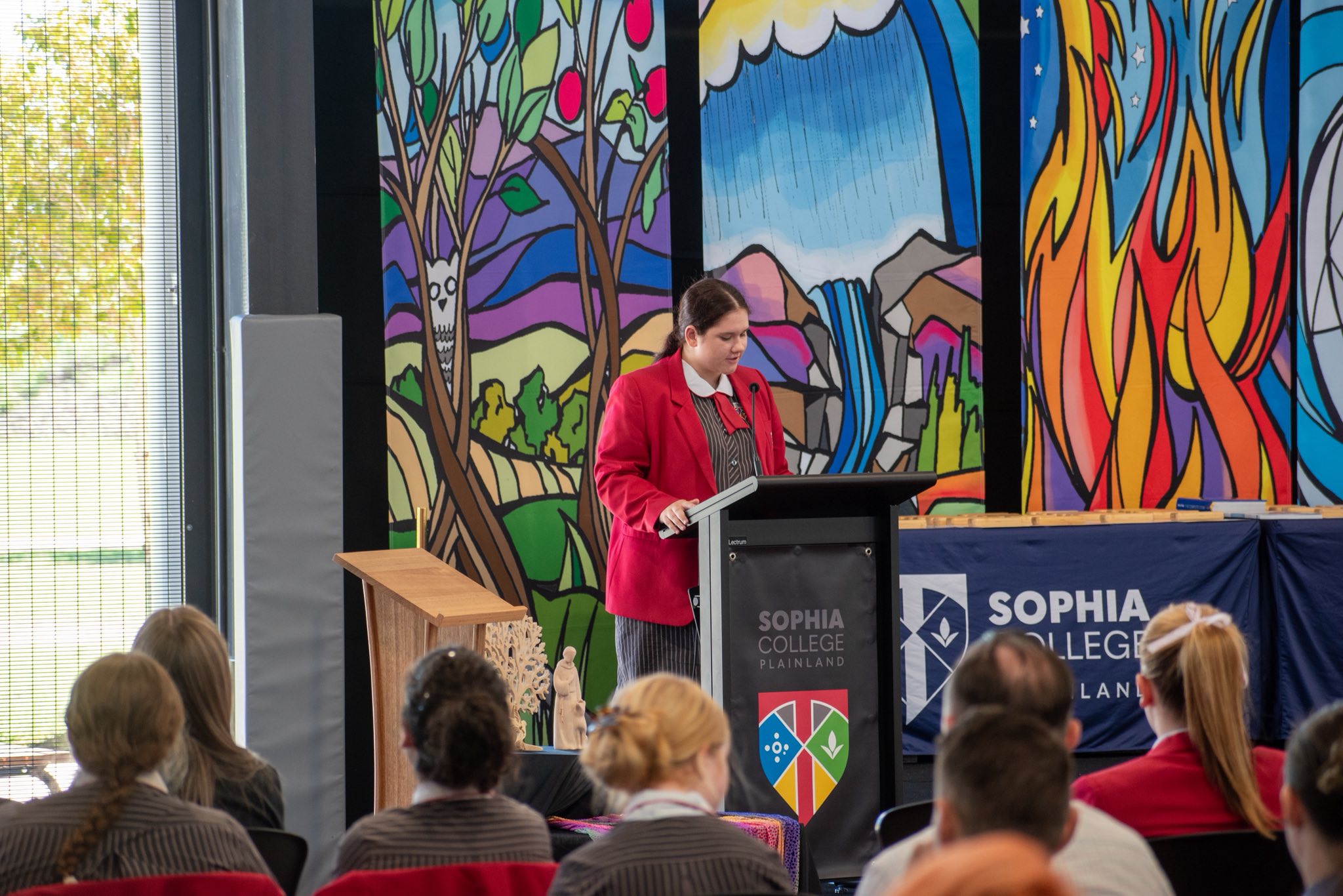 Student speaking at podium at end of year mass.